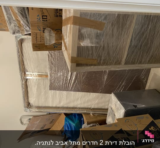 ארגזים ופריטים עטופים בניילון למעבר דירה